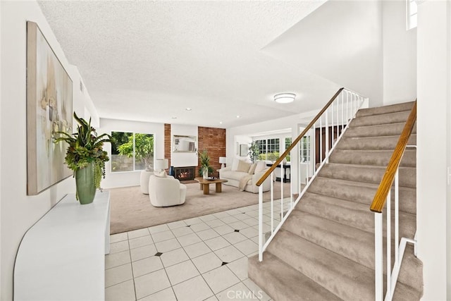 tiled entryway with a large fireplace and a textured ceiling