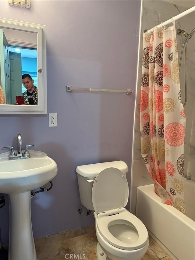 bathroom featuring shower / bathtub combination with curtain, tile patterned floors, and toilet