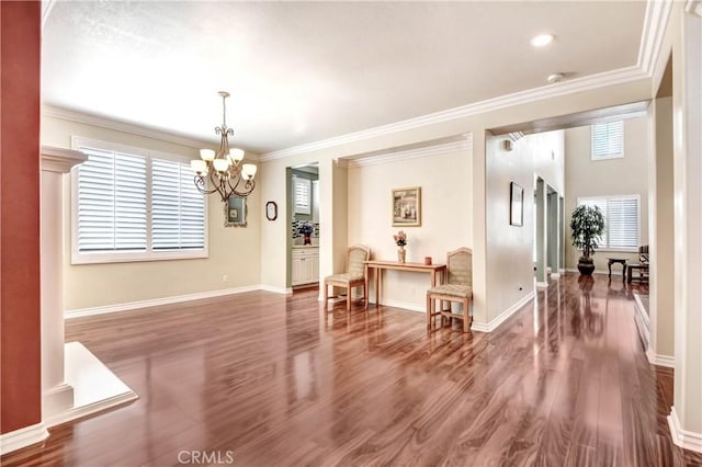 interior space with crown molding, a chandelier, hardwood / wood-style floors, and a wealth of natural light