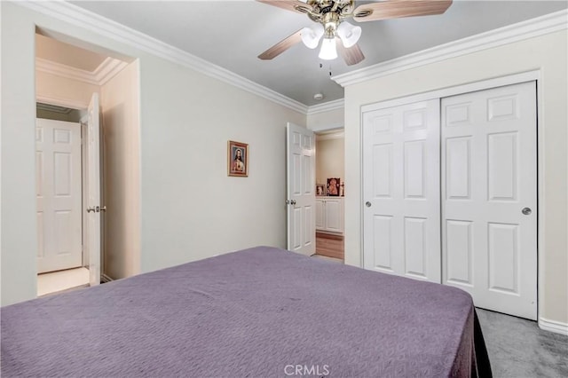 unfurnished bedroom featuring ornamental molding, carpet, ceiling fan, and a closet