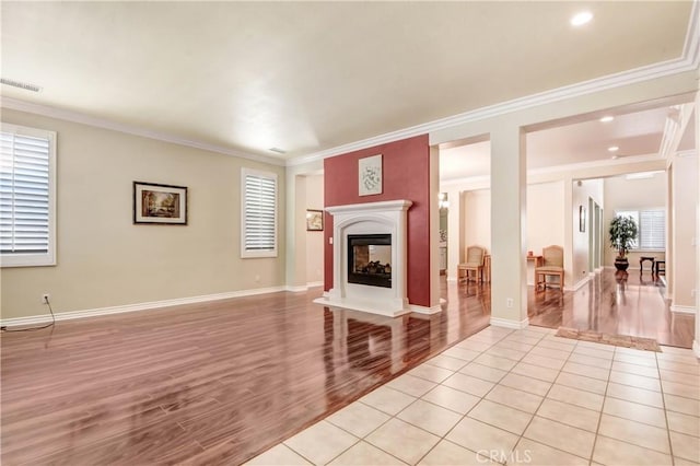 unfurnished living room with light tile patterned flooring and crown molding