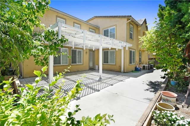 rear view of house featuring a pergola and a patio