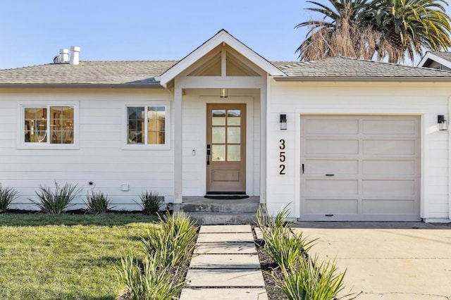 entrance to property with a garage and a yard