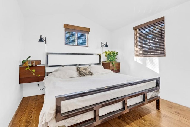 bedroom featuring vaulted ceiling and hardwood / wood-style floors