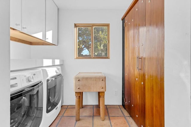 washroom featuring washer and dryer, light tile patterned floors, and cabinets