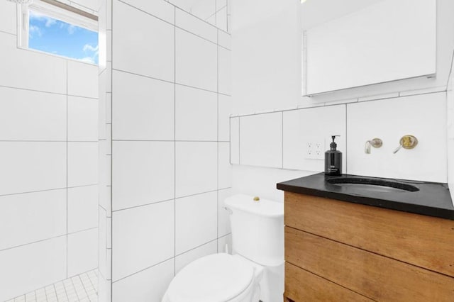 bathroom featuring tasteful backsplash, vanity, toilet, and tile walls