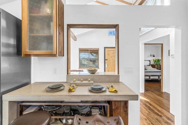 kitchen featuring stainless steel refrigerator, lofted ceiling, and hardwood / wood-style floors