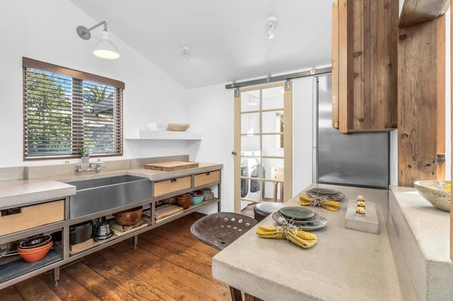 kitchen with vaulted ceiling, wood-type flooring, and sink