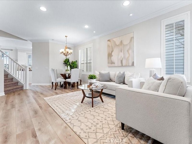 living room featuring hardwood / wood-style flooring, ornamental molding, and an inviting chandelier