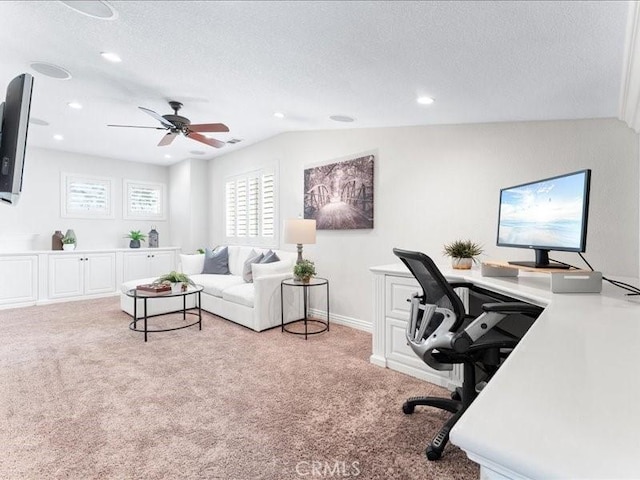 carpeted office space featuring vaulted ceiling, ceiling fan, and a textured ceiling