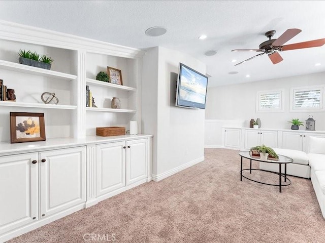 living area with ceiling fan and light carpet