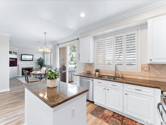 kitchen with decorative light fixtures, dishwasher, and white cabinets