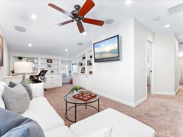 carpeted living room featuring ceiling fan and built in features