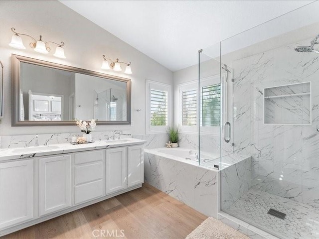 bathroom with vanity, hardwood / wood-style floors, vaulted ceiling, and separate shower and tub