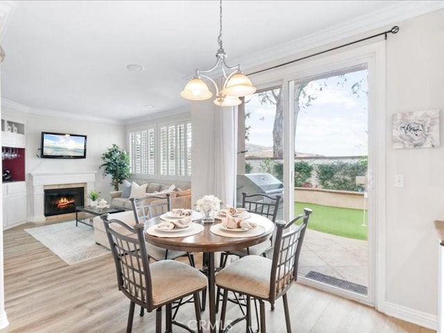 dining room featuring a notable chandelier, ornamental molding, and light wood-type flooring