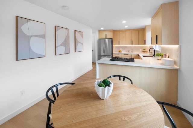 dining room with sink and light hardwood / wood-style flooring