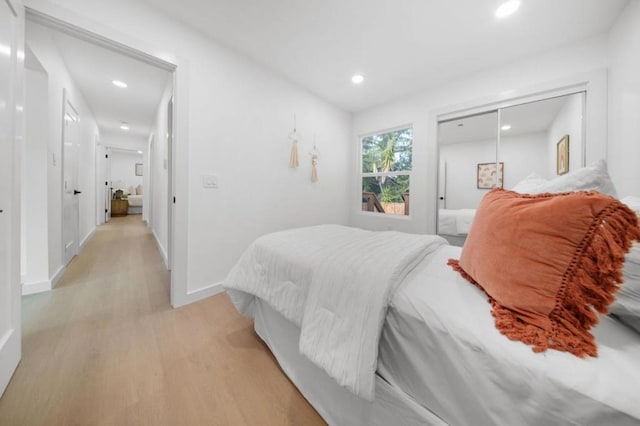 bedroom with light hardwood / wood-style floors and a closet