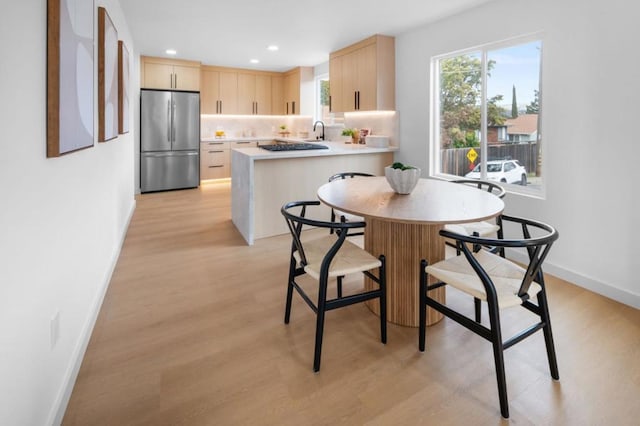 dining space featuring sink and light wood-type flooring