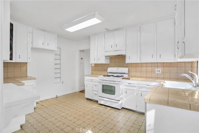 kitchen featuring white cabinetry, white gas range, tasteful backsplash, and sink