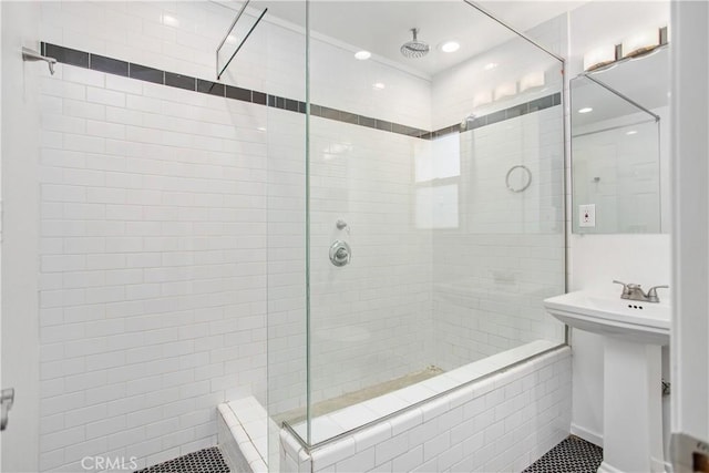 bathroom featuring sink and a tile shower