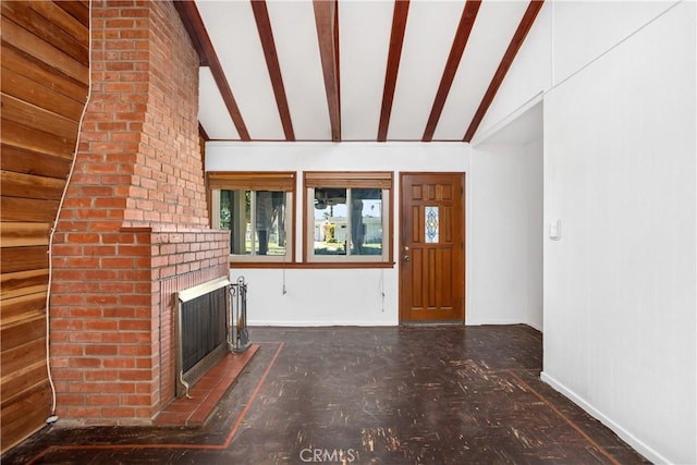 unfurnished living room featuring a fireplace and lofted ceiling with beams