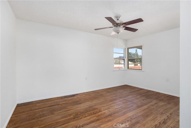 spare room featuring a textured ceiling, dark hardwood / wood-style floors, and ceiling fan