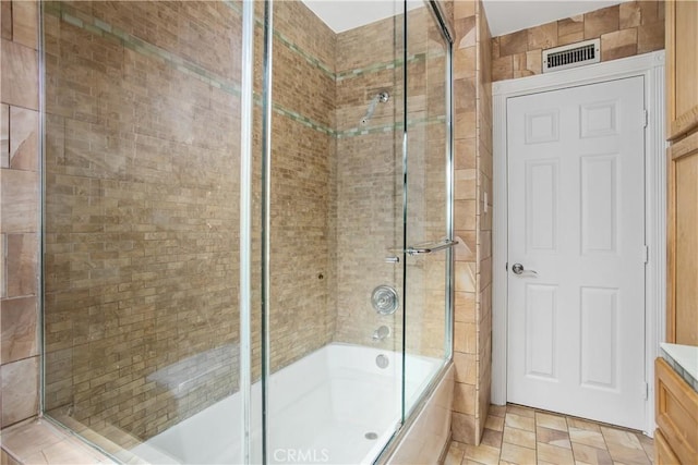 bathroom featuring vanity and combined bath / shower with glass door