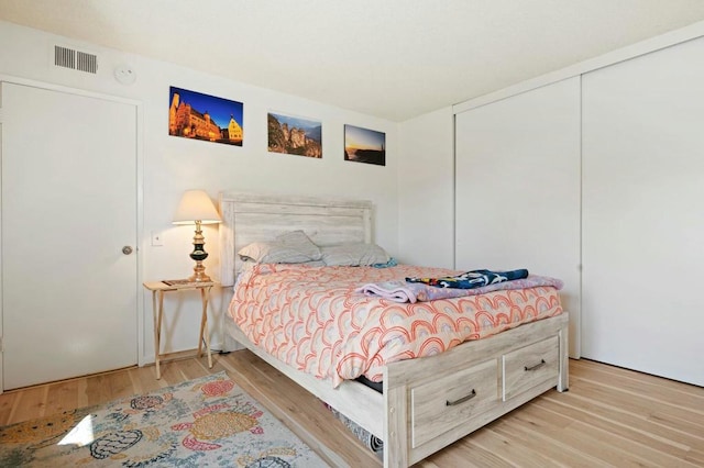 bedroom with light hardwood / wood-style floors and a closet