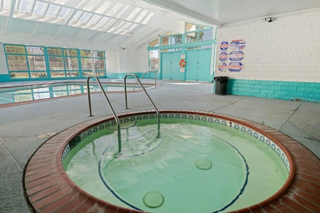 view of swimming pool with an indoor hot tub