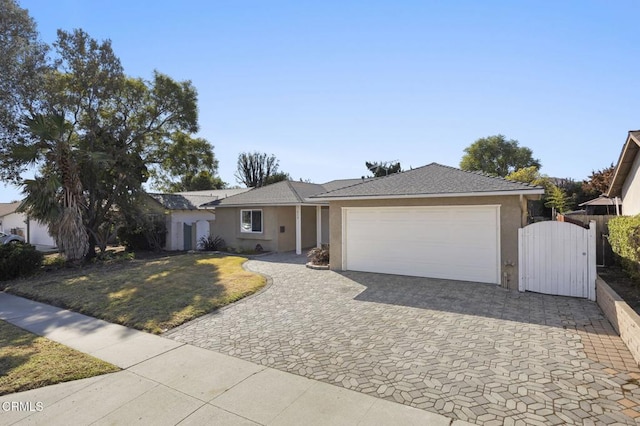 single story home featuring a garage and a front lawn