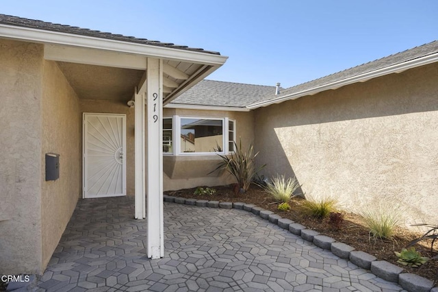 view of exterior entry with a patio