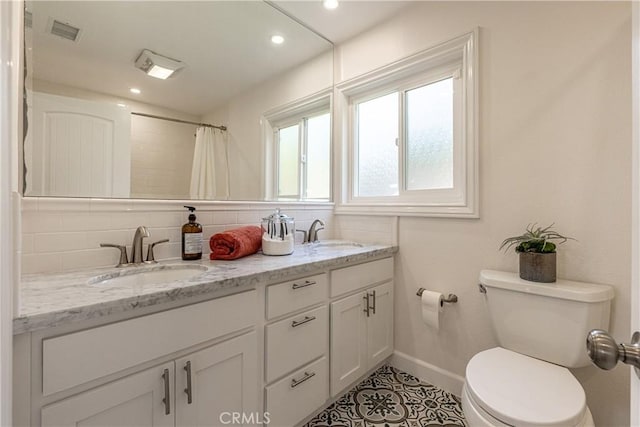 bathroom with toilet, curtained shower, vanity, and decorative backsplash