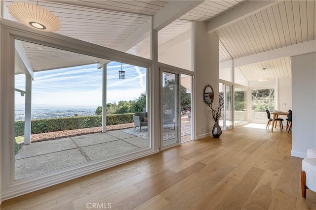 entryway with vaulted ceiling with beams, expansive windows, and light wood-type flooring