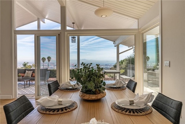 sunroom with lofted ceiling with beams and a healthy amount of sunlight