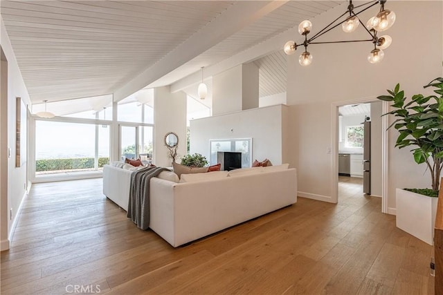 living room with a notable chandelier, beam ceiling, light hardwood / wood-style floors, and a wealth of natural light