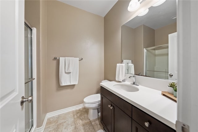 bathroom with vanity, baseboards, toilet, and a shower stall