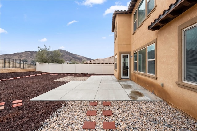 view of yard featuring a fenced backyard, a patio, and a mountain view