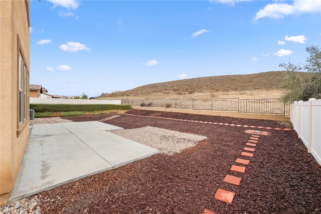 view of yard featuring a mountain view and a patio