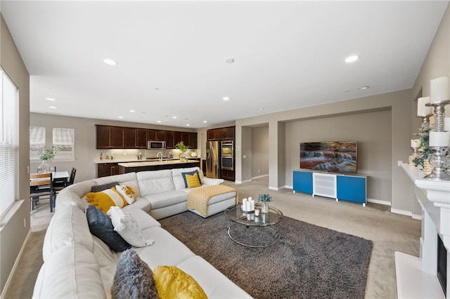 living area featuring baseboards, light colored carpet, and recessed lighting