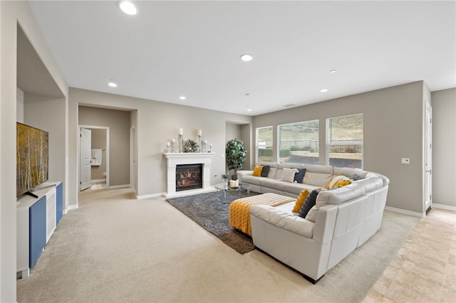 living room with baseboards, light colored carpet, recessed lighting, and a glass covered fireplace