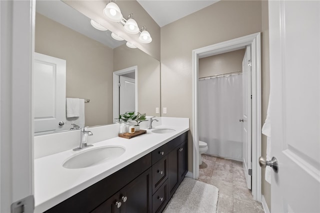 bathroom with toilet, a sink, curtained shower, and double vanity