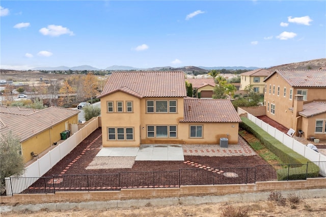 back of house with a mountain view and central AC