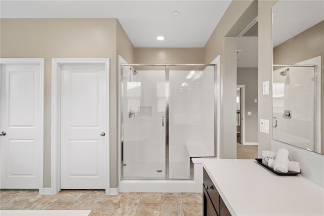 bathroom with a shower stall, baseboards, and vanity