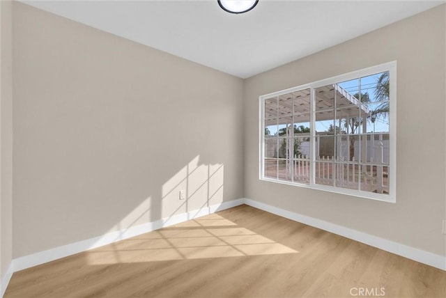 unfurnished room featuring a wealth of natural light and wood-type flooring