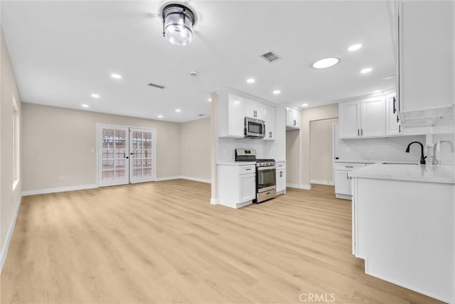 kitchen featuring white cabinetry, appliances with stainless steel finishes, and light hardwood / wood-style floors