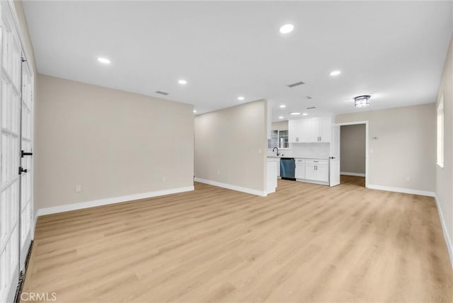 unfurnished living room with sink and light hardwood / wood-style flooring