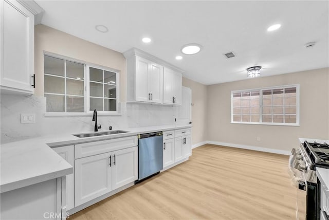 kitchen with white cabinetry, sink, stainless steel appliances, and light hardwood / wood-style floors