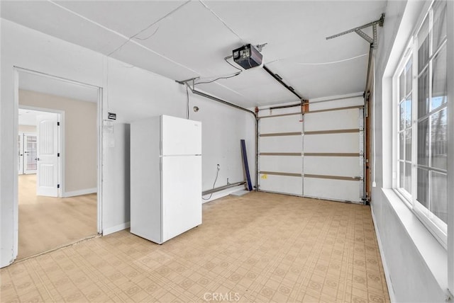 garage featuring a garage door opener and white fridge