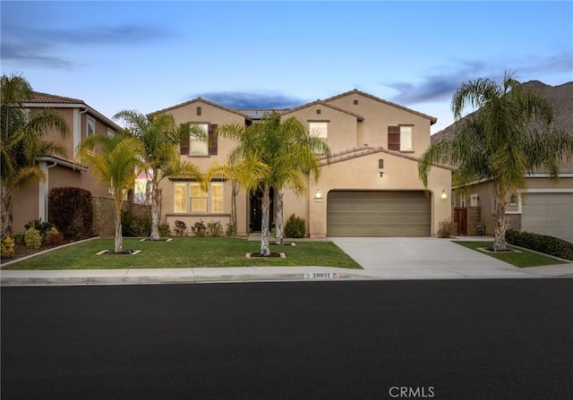 mediterranean / spanish-style home featuring a garage and a front yard