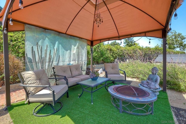 view of patio / terrace featuring a gazebo and an outdoor living space with a fire pit